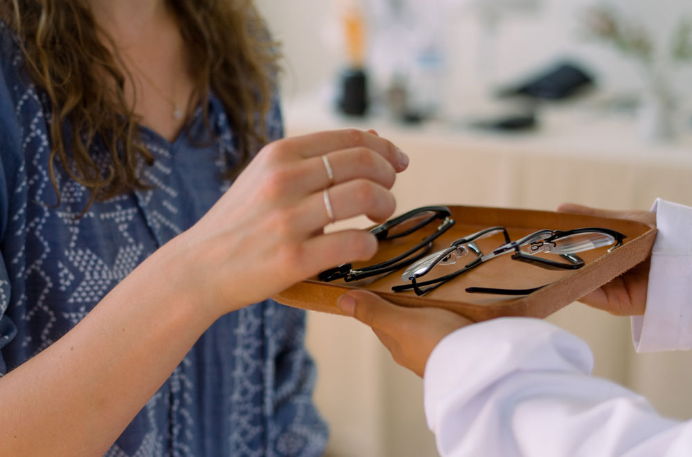 woman picking out glasses